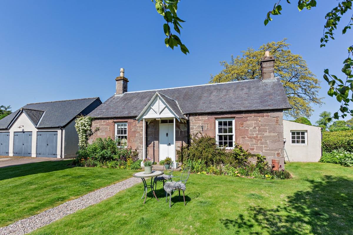 The detached, stone-built Gardener's Cottage with lawn and flower beds